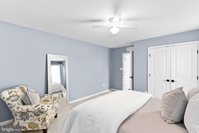 carpeted bedroom with a closet, baseboards, and ceiling fan