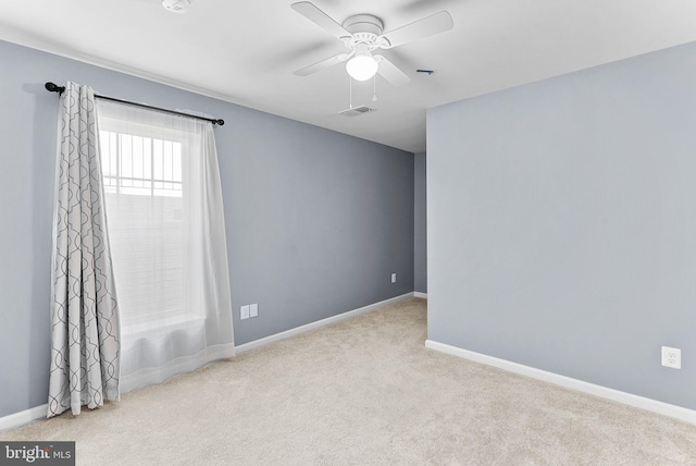 spare room with carpet flooring, ceiling fan, and baseboards