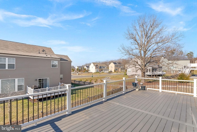 wooden deck featuring a residential view and a lawn