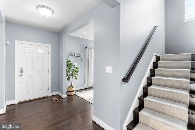 foyer with stairway, baseboards, and wood finished floors