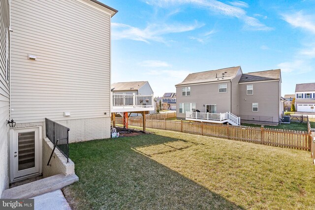 view of yard featuring a residential view, central AC unit, and fence