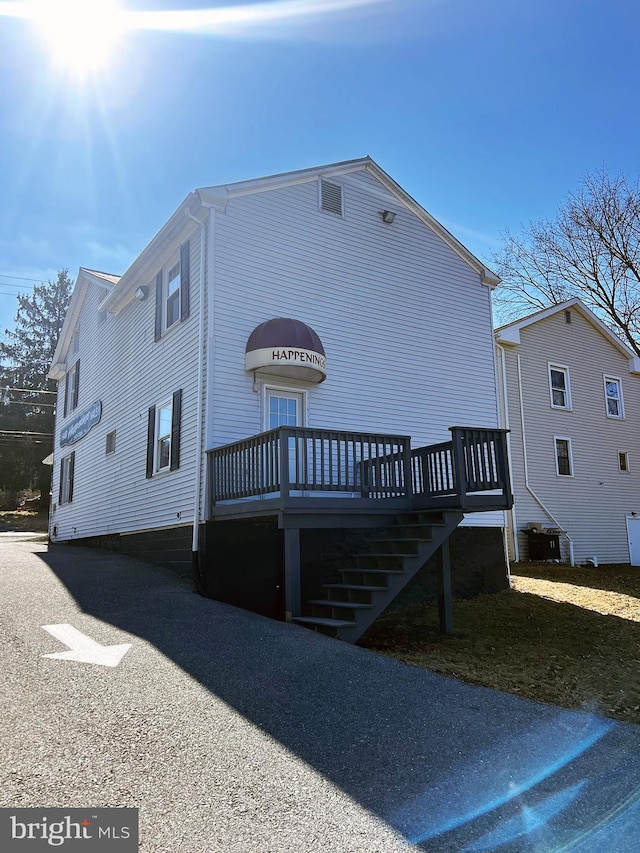 view of front of home with stairs and a deck