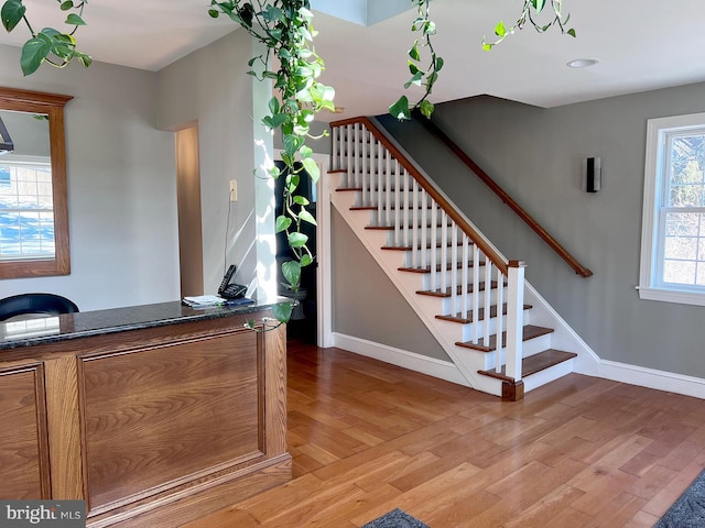 stairway featuring baseboards and wood finished floors