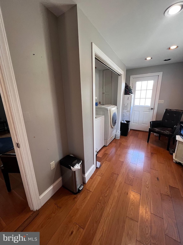 washroom with laundry area, light wood finished floors, baseboards, washing machine and clothes dryer, and recessed lighting