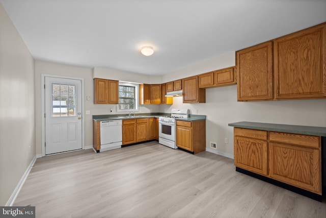 kitchen featuring light wood finished floors, white appliances, brown cabinets, and under cabinet range hood