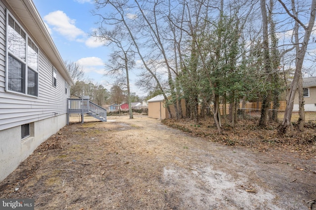 view of yard with an outdoor structure, a storage shed, and fence