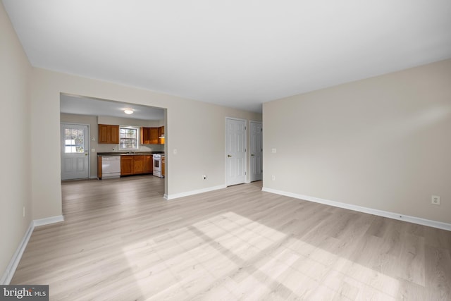 unfurnished living room featuring light wood-style flooring and baseboards