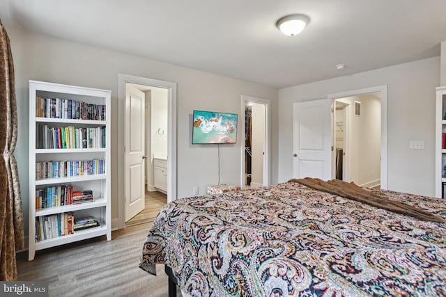 bedroom with ensuite bathroom and wood finished floors