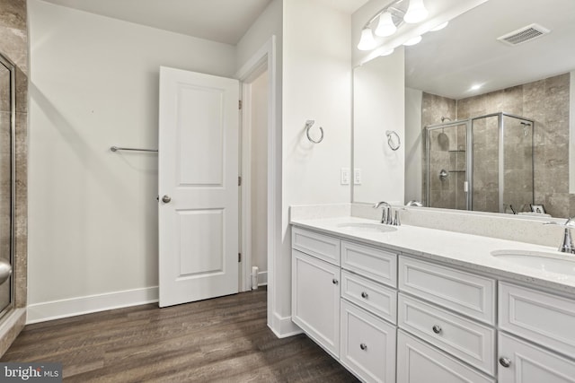 bathroom featuring visible vents, a stall shower, and a sink