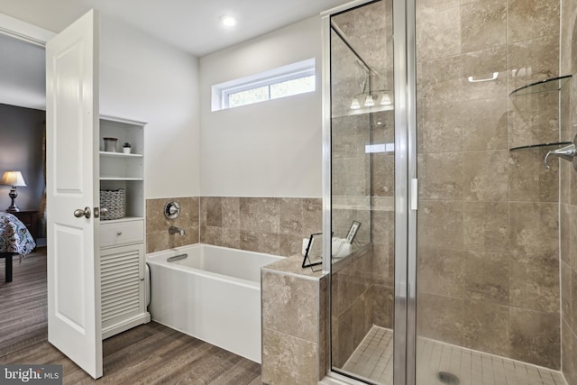 ensuite bathroom with a bath, wood finished floors, a stall shower, and ensuite bathroom