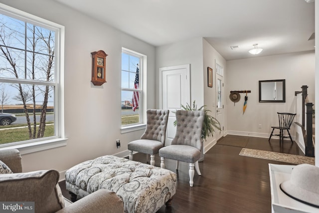 living area with plenty of natural light, baseboards, and dark wood-style flooring