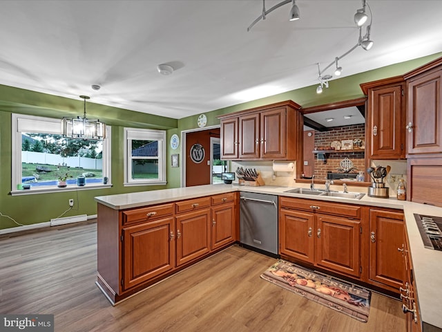 kitchen featuring dishwasher, light countertops, a peninsula, and a sink