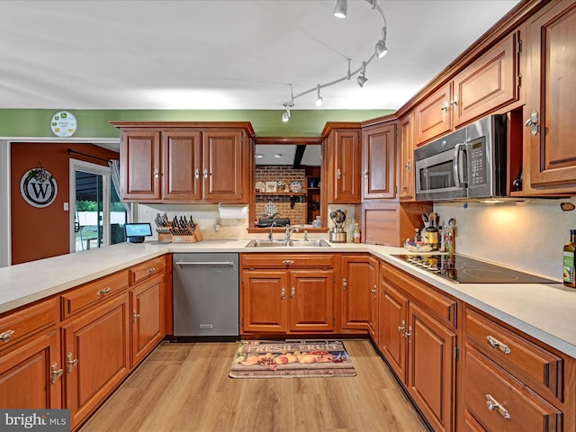 kitchen featuring light countertops, a sink, dishwasher, and black electric stovetop