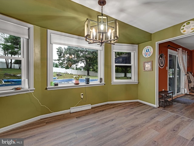 unfurnished dining area with an inviting chandelier, wood finished floors, visible vents, and a healthy amount of sunlight