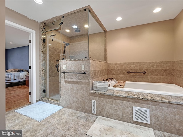 ensuite bathroom featuring a garden tub, recessed lighting, visible vents, a stall shower, and connected bathroom