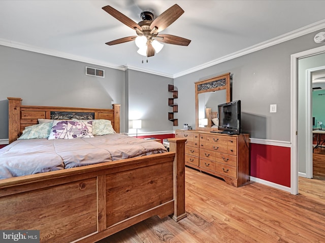 bedroom featuring ornamental molding, light wood finished floors, visible vents, and baseboards