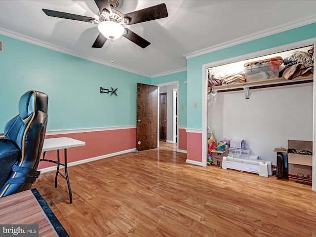 office space featuring crown molding, baseboards, ceiling fan, and wood finished floors