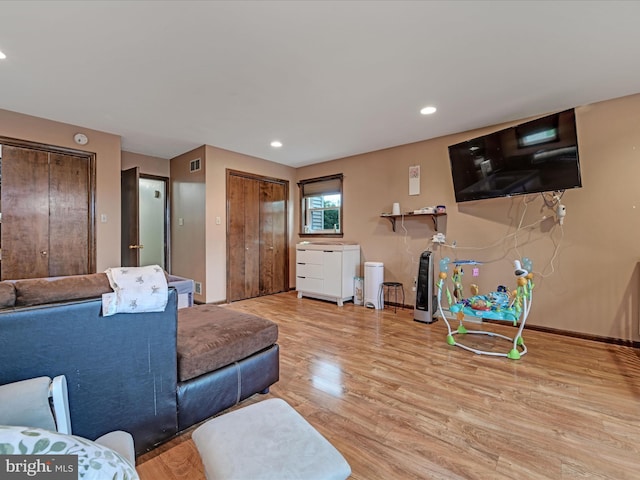 living area featuring light wood finished floors, visible vents, baseboards, and recessed lighting