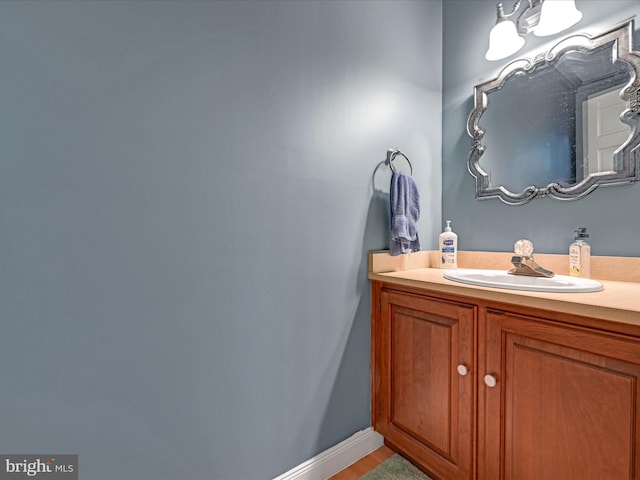 bathroom with baseboards, wood finished floors, and vanity