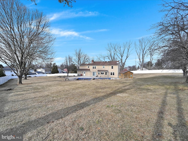 back of property with a yard and fence