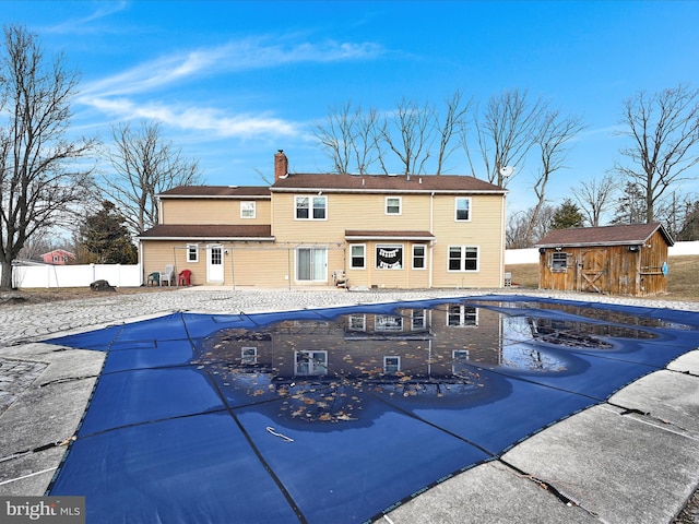 view of pool featuring a fenced in pool, an outbuilding, a storage shed, a patio area, and fence