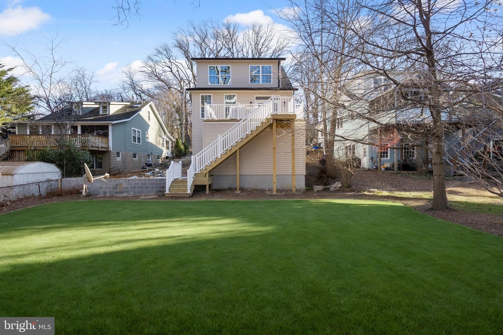 back of property with stairway and a lawn