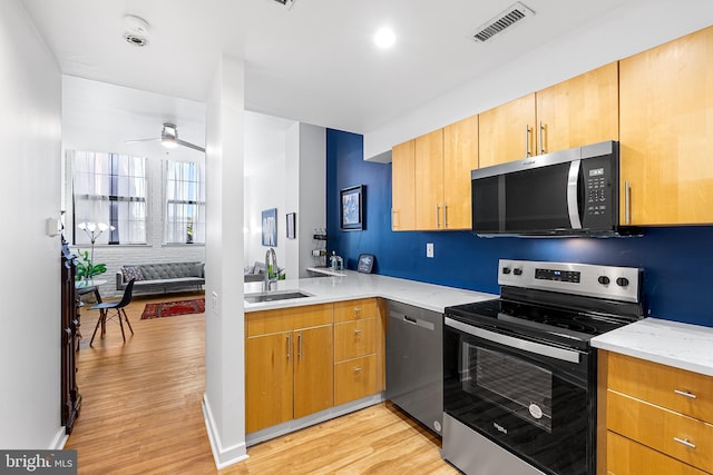 kitchen with light wood-type flooring, visible vents, appliances with stainless steel finishes, and a sink