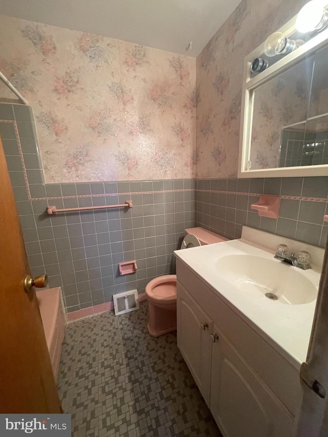 full bathroom featuring wallpapered walls, visible vents, and wainscoting