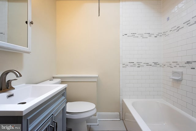 bathroom featuring baseboards, toilet, shower / washtub combination, and vanity