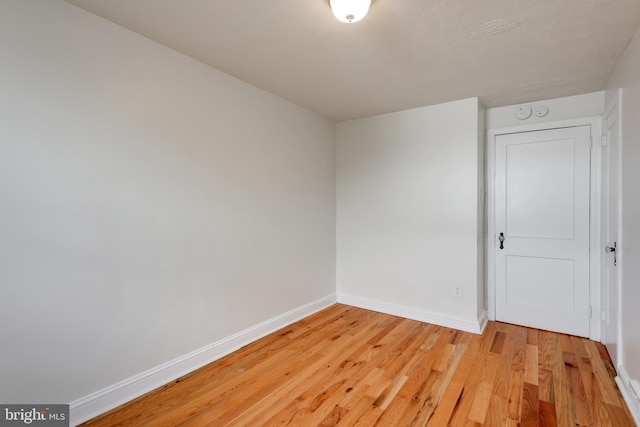 unfurnished room featuring baseboards and light wood-style floors