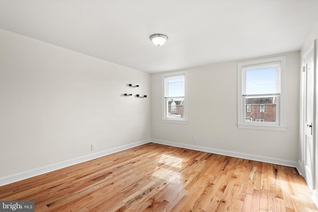 unfurnished room featuring baseboards and light wood-type flooring