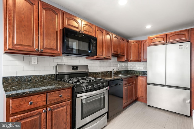 kitchen with tasteful backsplash, recessed lighting, dark stone countertops, black appliances, and a sink