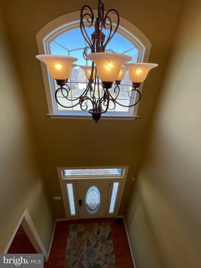 entryway featuring an inviting chandelier, baseboards, and wood finished floors