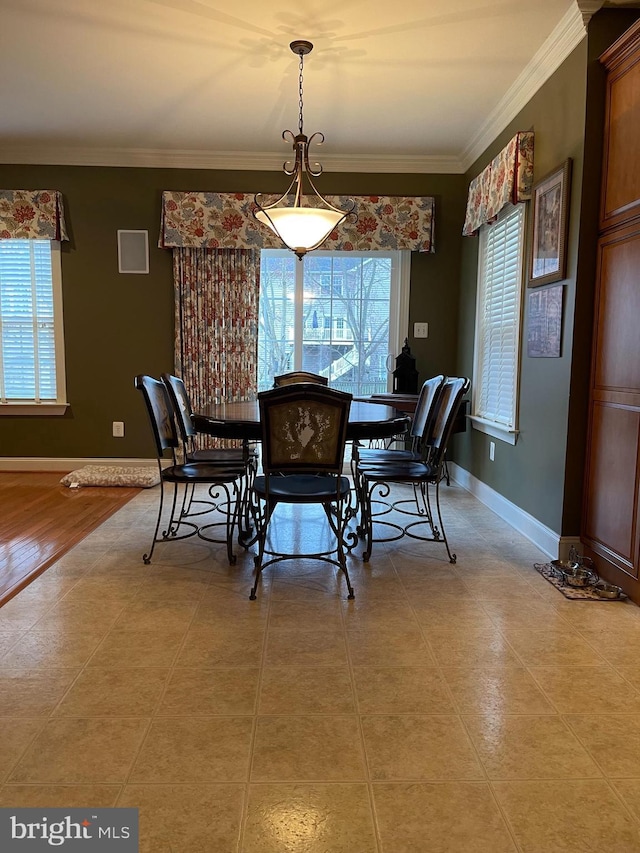 dining area with baseboards and crown molding