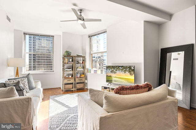 living area with visible vents, wood finished floors, and a ceiling fan