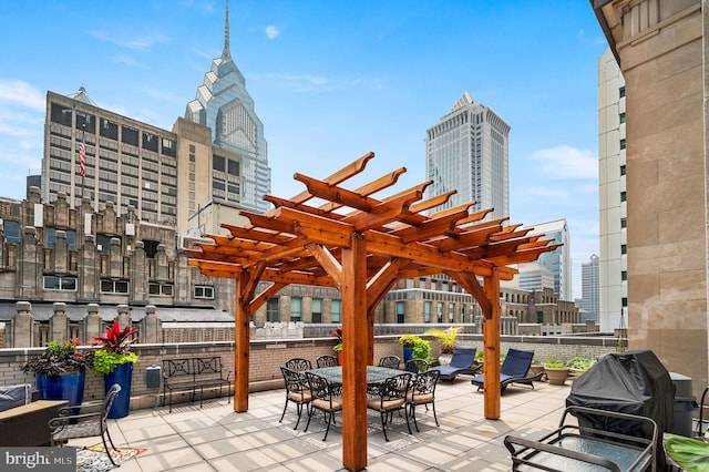 view of patio featuring a city view, a grill, and a pergola