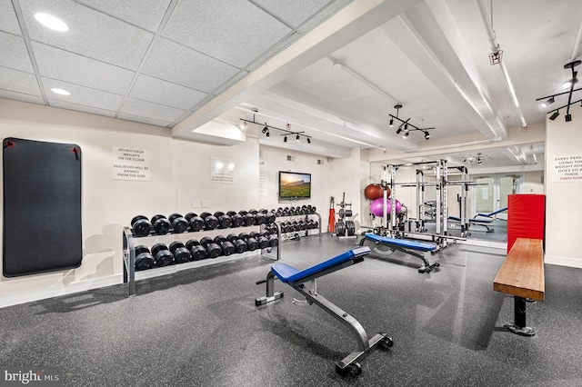 gym with rail lighting, recessed lighting, baseboards, and a drop ceiling