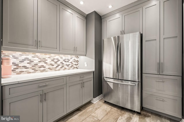 kitchen featuring tasteful backsplash, recessed lighting, gray cabinets, and freestanding refrigerator