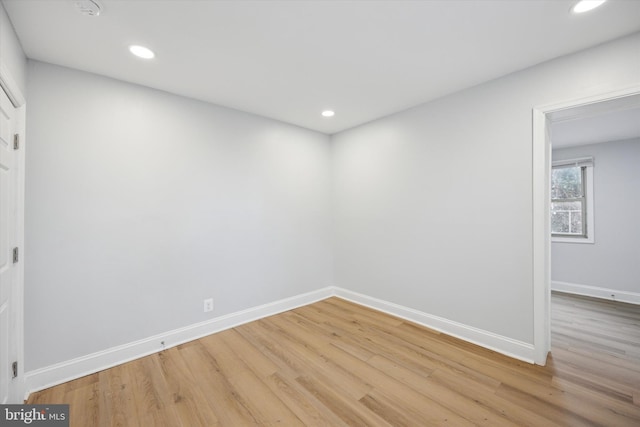 spare room featuring recessed lighting, light wood-type flooring, and baseboards