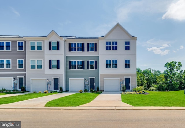 view of property featuring an attached garage, driveway, and a front lawn