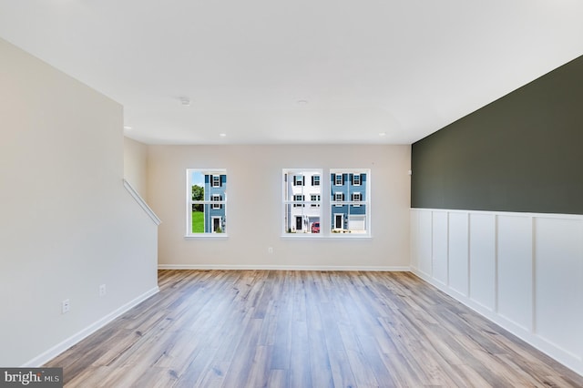 spare room with baseboards and wood finished floors