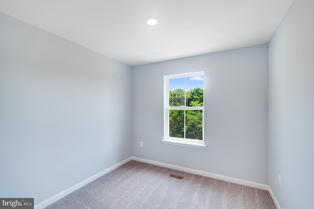 empty room featuring baseboards, visible vents, and carpet flooring