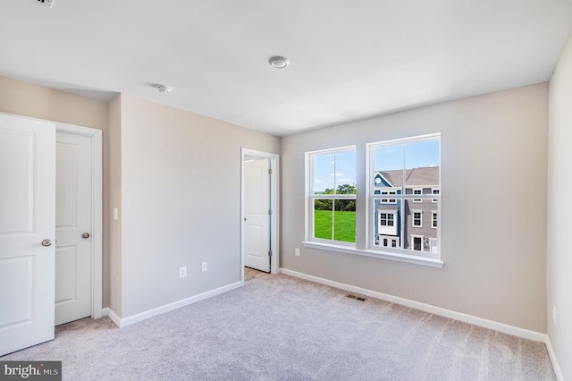 unfurnished bedroom with baseboards, visible vents, and carpet flooring