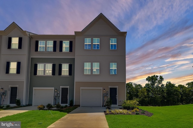 townhome / multi-family property featuring a garage, concrete driveway, and a front yard