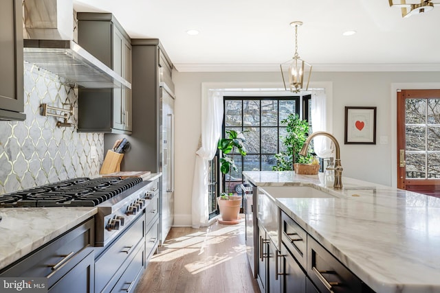 kitchen with wall chimney range hood, tasteful backsplash, stainless steel gas cooktop, and ornamental molding