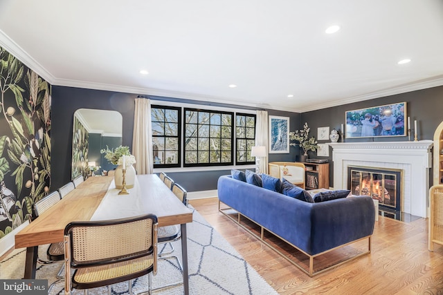 living room with baseboards, a fireplace with flush hearth, wood finished floors, crown molding, and recessed lighting