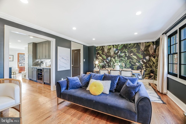 living area featuring wallpapered walls, wine cooler, and ornamental molding