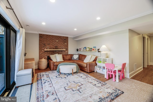 living room featuring visible vents, baseboards, wood finished floors, crown molding, and recessed lighting