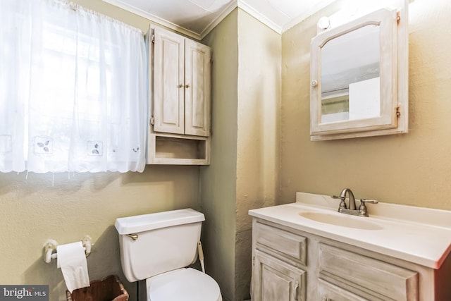 half bath featuring toilet, a textured wall, ornamental molding, and vanity