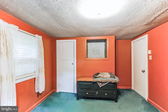 interior space with a textured ceiling and baseboards